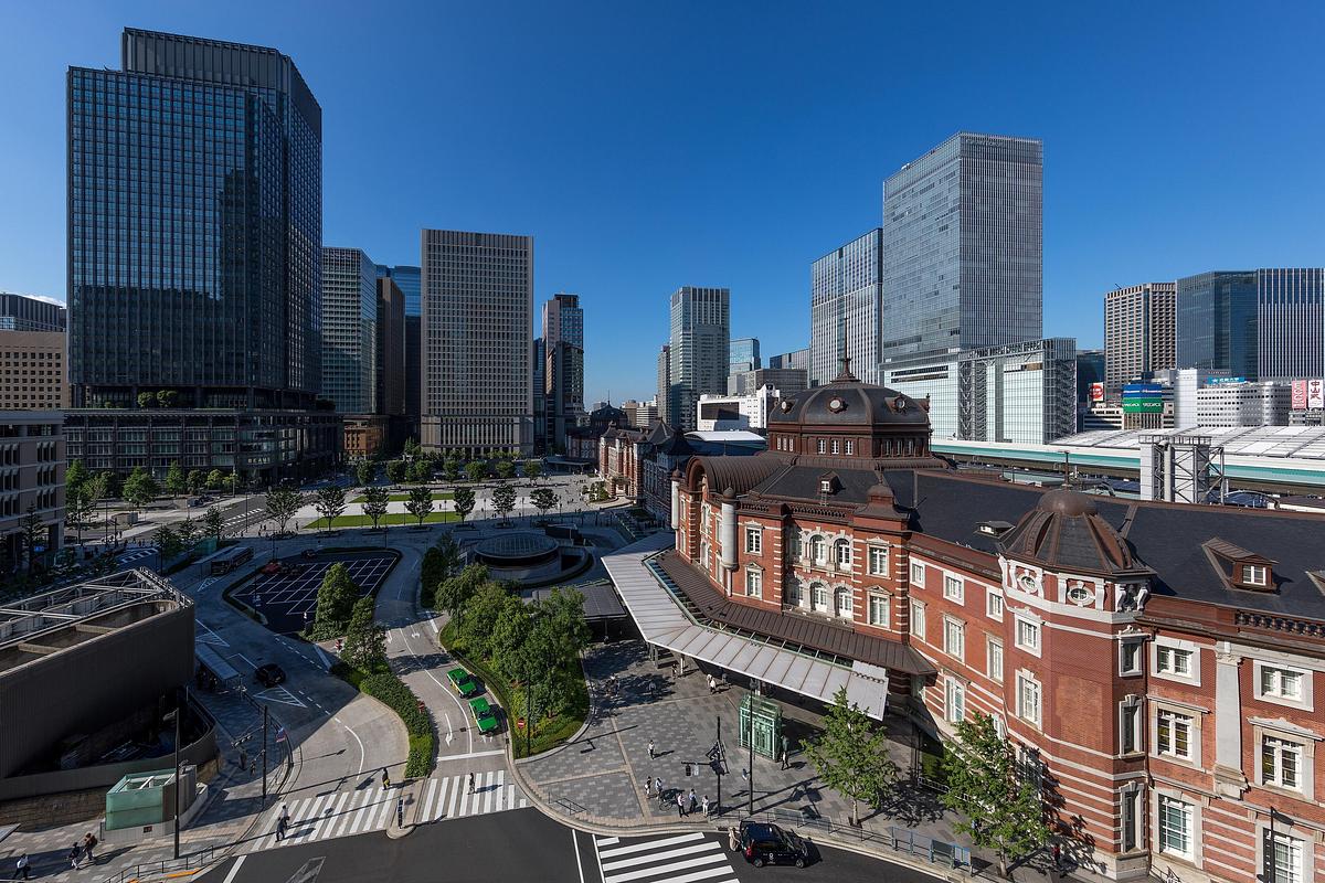 晴れた日の東京駅の赤レンガの駅舎と丸の内駅前広場を、高い所から見た景色